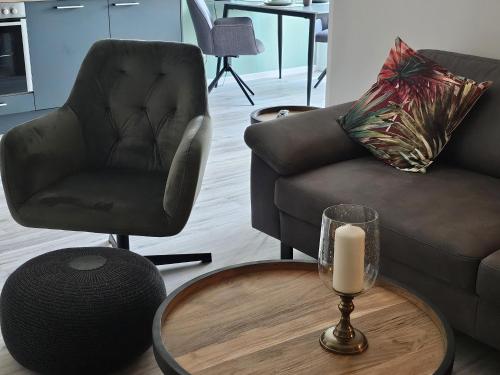 a living room with a chair and a table with a candle at Ferienwohnung Nationalpark in Nideggen