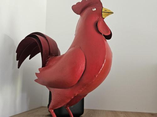 a red chicken statue sitting on top of a table at Ferienwohnung Nationalpark in Nideggen