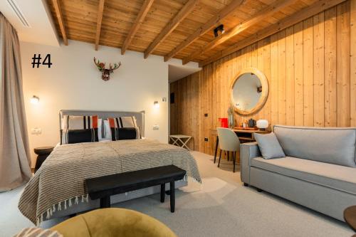 a bedroom with a bed and a couch and a table at The Pines Bucegi Lodge in Bran