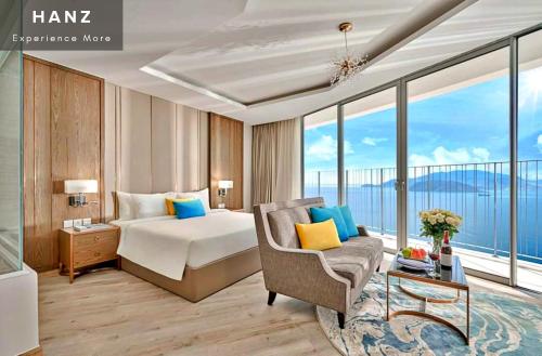 a hotel room with a bed and a chair and windows at S79 Residences LYN Panorama Suite in Nha Trang