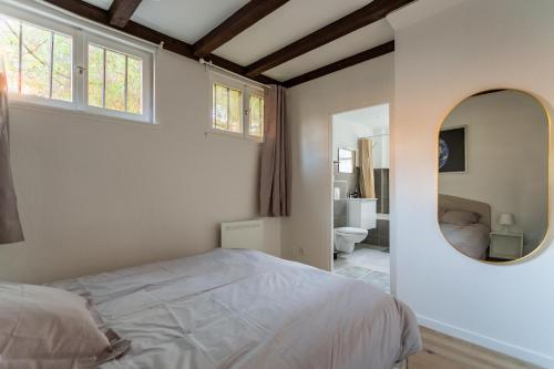 - une chambre avec un lit et un miroir rond dans l'établissement Confort au cœur de Strasbourg, à Strasbourg