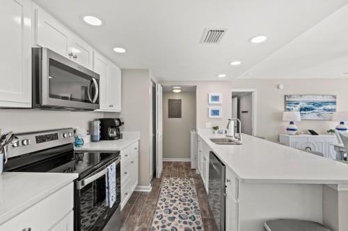 a kitchen with white counter tops and appliances at Sandpiper Beacon Beach Resort in Panama City Beach