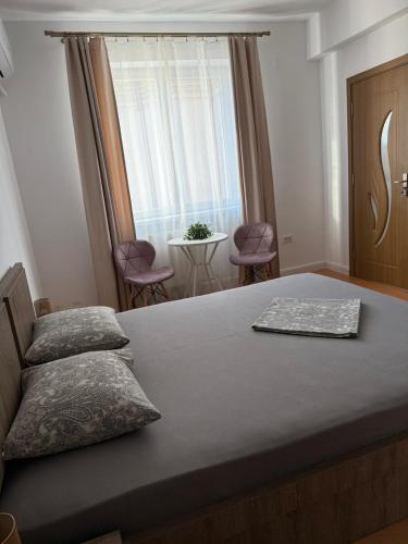a bedroom with a bed and a window and chairs at Studio Central PCS in Bucharest