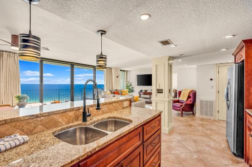 a kitchen with a sink and a view of the ocean at Sandpiper Beacon Beach Resort in Panama City Beach