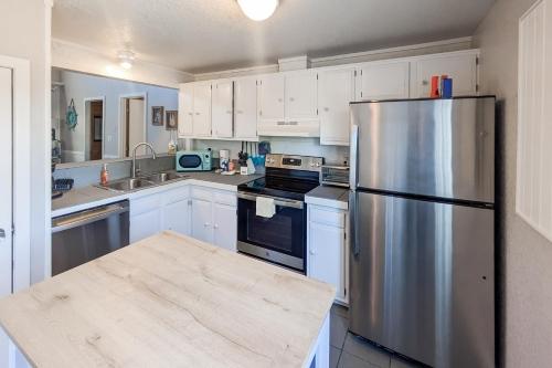 a kitchen with white cabinets and a stainless steel refrigerator at Piper's Nest AV927 in Avon