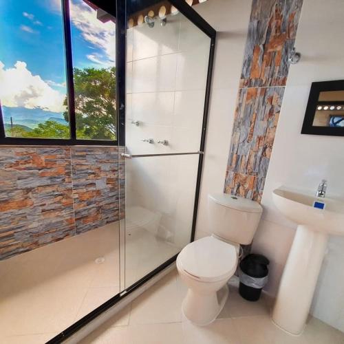 a bathroom with a toilet and a shower and a sink at Villas del bambú in San Gil