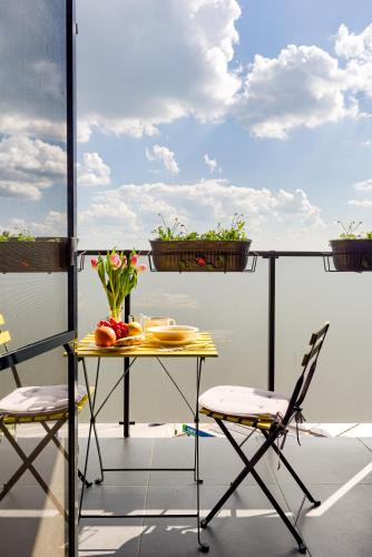 a table and two chairs on a balcony with flowers at ARI - ARED Luxurious Apartments with Balcony & Free Parking in Arad