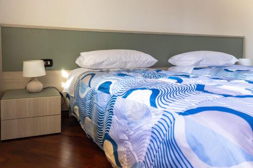 a large bed with a blue and white comforter at Villa Carlotta in Nuxis