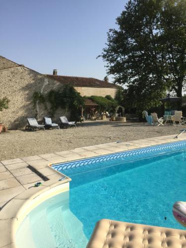 a swimming pool with a bench next to a house at L'Oree du Bois in Cherbonnières