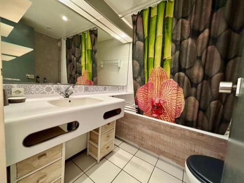 ein Badezimmer mit Waschbecken und Duschvorhang in der Unterkunft *Au Lydia* Appartement vue sur mer, avec piscine. in Le Barcarès