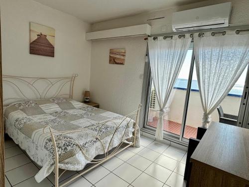 ein Schlafzimmer mit Bett und Meerblick in der Unterkunft *Au Lydia* Appartement vue sur mer, avec piscine. in Le Barcarès