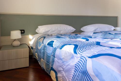 a large bed with a blue and white comforter and pillows at Villa Carlotta in Nuxis