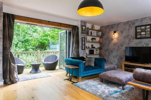a living room with a blue couch and a balcony at Luxury -chelt Walking-2bed-long Stays-parking in Cheltenham