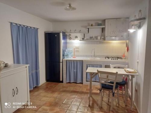 a small kitchen with a table and a refrigerator at Labanca's l'arco del duomo in Matera