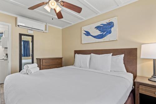 a bedroom with a bed and a ceiling fan at Sandpiper Beacon Beach Resort in Panama City Beach