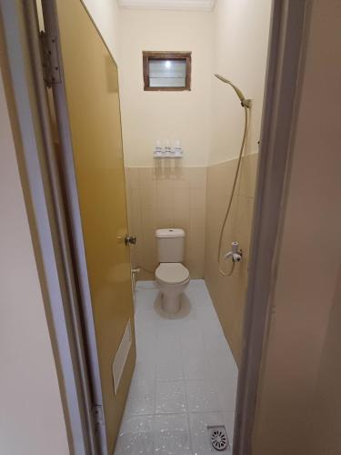 a small bathroom with a toilet and a shower at M2 Homestay Jogja in Jarakan