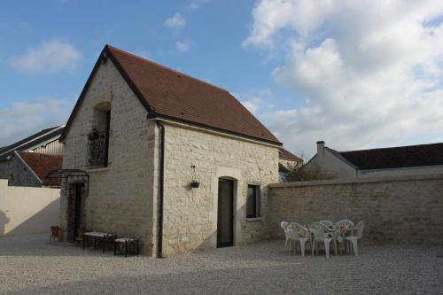 a building with tables and chairs in front of it at Charmante Maison Pierres 1768 in Polisy