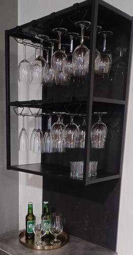a shelf with wine glasses and bottles on it at Villa Finlandia, Tornio at the border of Finland and Sweden in Tornio