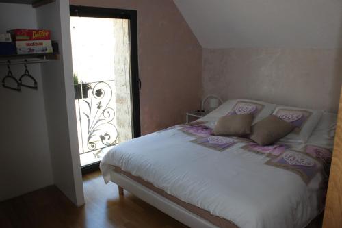 a bedroom with a white bed with a window at Charmante Maison Pierres 1768 in Polisy
