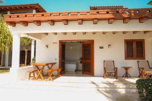 a patio with a table and chairs in front of a house at Refugio de piedra - Troncones in Troncones