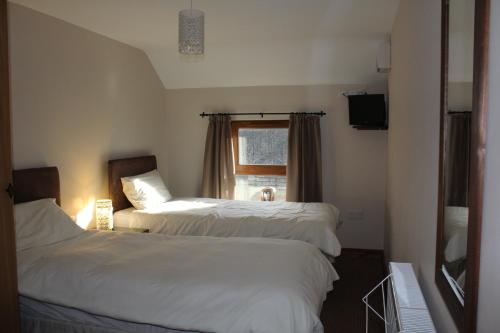 a bedroom with two beds and a window at The Nags Head Tredegar in Nant-y-bwch