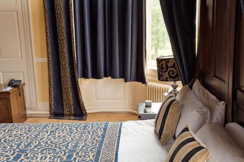 a bedroom with a bed with curtains and a window at Walworth Castle Hotel, BW Signature Collection in Darlington