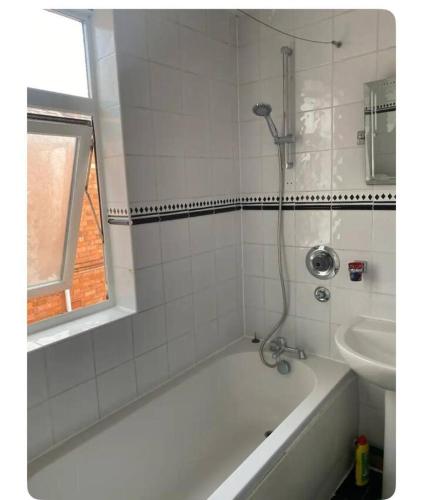 a bathroom with a bath tub and a sink at Balfour House in Leicester