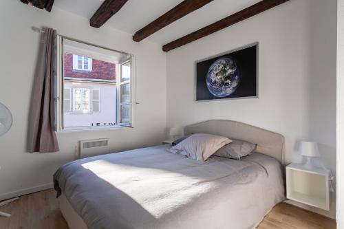 une chambre avec un lit dans une pièce avec une fenêtre dans l'établissement Appartement au centre de Strasbourg, à Strasbourg