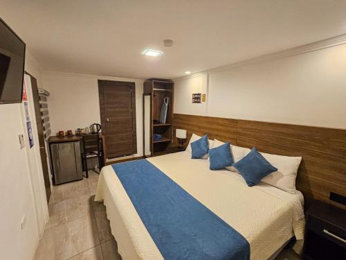 a bedroom with a large bed with blue pillows at Plaza Lobos in Puerto Baquerizo Moreno