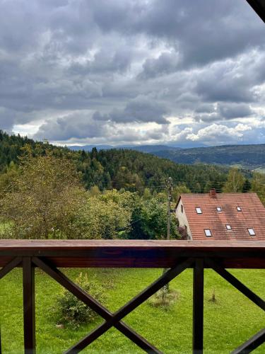 a view from a balcony of a house in a field at Klimatyczny Dom z widokiem na Babią Górę in Maków Podhalański