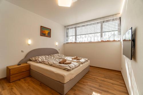 a small bedroom with a bed and a window at Winifera Penzion in Pavlov