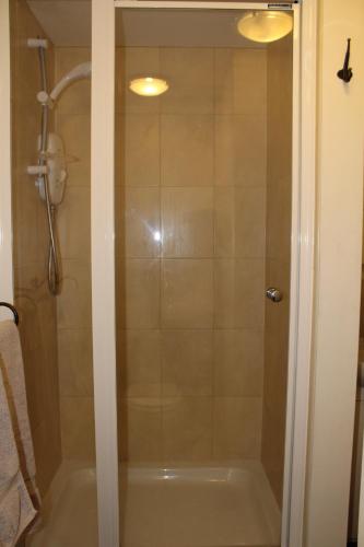 a shower with a glass door in a bathroom at The Nags Head Tredegar in Nant-y-bwch