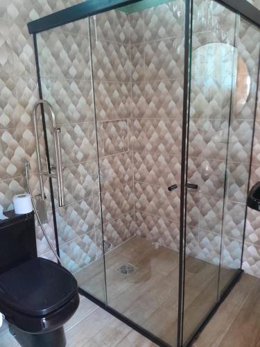 a glass shower with a toilet in a bathroom at Cabañas Compartidas en Casa Quinta en Itá in Itauguá