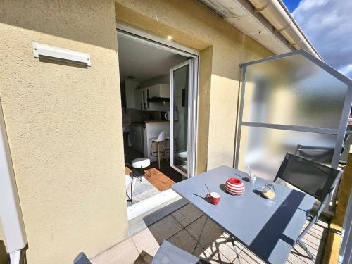 une table bleue et des chaises sur un balcon dans l'établissement T2 neuf - centre - Parking supp, à Toulouse