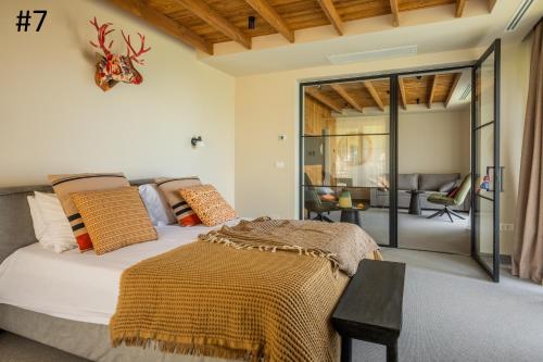 a bedroom with a bed and a living room at The Pines Bucegi Lodge in Bran