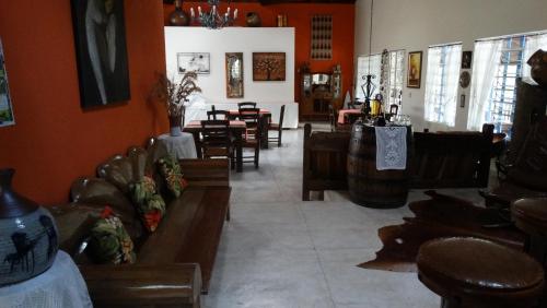 a restaurant with wooden chairs and tables and a room with orange walls at Pousada Cheiro da Terra in Cunha