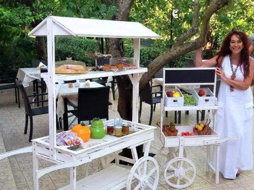 a woman standing in front of a table with food at Villa Felicia in Noto