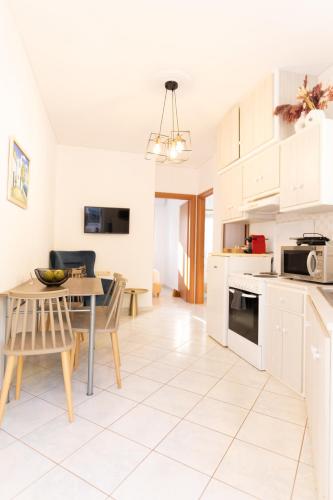 a kitchen and dining room with a table and chairs at Ammoudeli Apartments in Plomarion