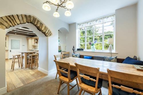une salle à manger et une cuisine avec une table et des chaises dans l'établissement Large Grade II Listed House & Garden nr Beaches, à Saint Columb Major