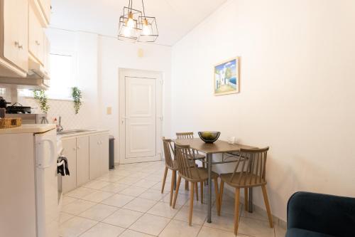 a kitchen and dining room with a table and chairs at Ammoudeli Apartments in Plomarion