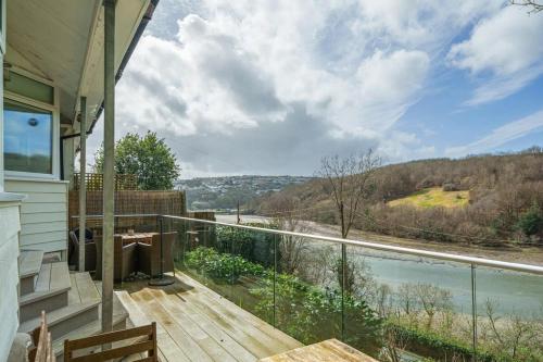 a house with a balcony with a view of the water at Cosy Home on the Waterfront Private Parking in Looe