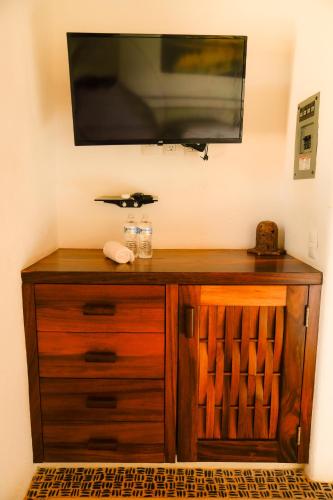 a flat screen tv on top of a wooden cabinet at Refugio de piedra - Troncones in Troncones