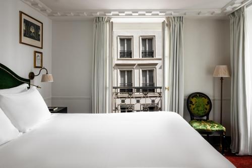 a bedroom with a large white bed and a window at La Chambre du Marais in Paris