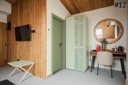 a room with a desk and a mirror and a door at The Pines Bucegi Lodge in Bran
