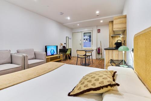 a bedroom with a bed and a living room at Apartamentos Beatriz by gaiarooms in Salamanca