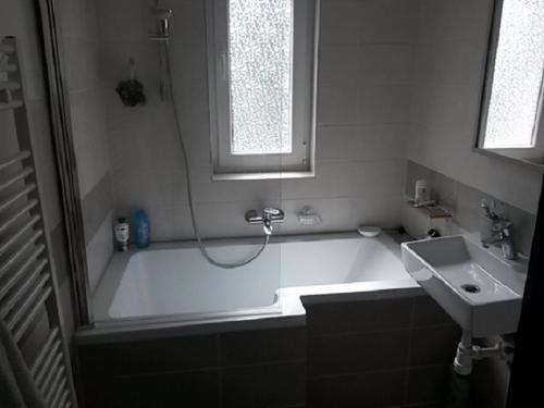 a bathroom with a bath tub and a sink at Panorama Apartman in Zamárdi