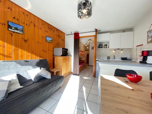 un salon avec un canapé et une cuisine dans l'établissement Appartement calme près village et commerces, équipé pour 4 pers. - FR-1-505-168, à Notre-Dame-de-Bellecombe
