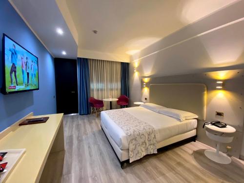 a hotel room with a bed and a tv at Hotel Motel Visconteo in Binasco
