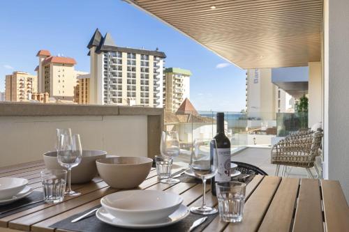 フエンヒロラにあるViVi Homes - Jade Beautiful Apartment with Spa, Pool and Cinema 200 meters from the beachのテーブル(ボトルワイン1本、グラス付)