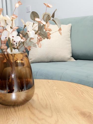 a vase with flowers sitting on a wooden table at Apartman COMO, private parking free in Košice